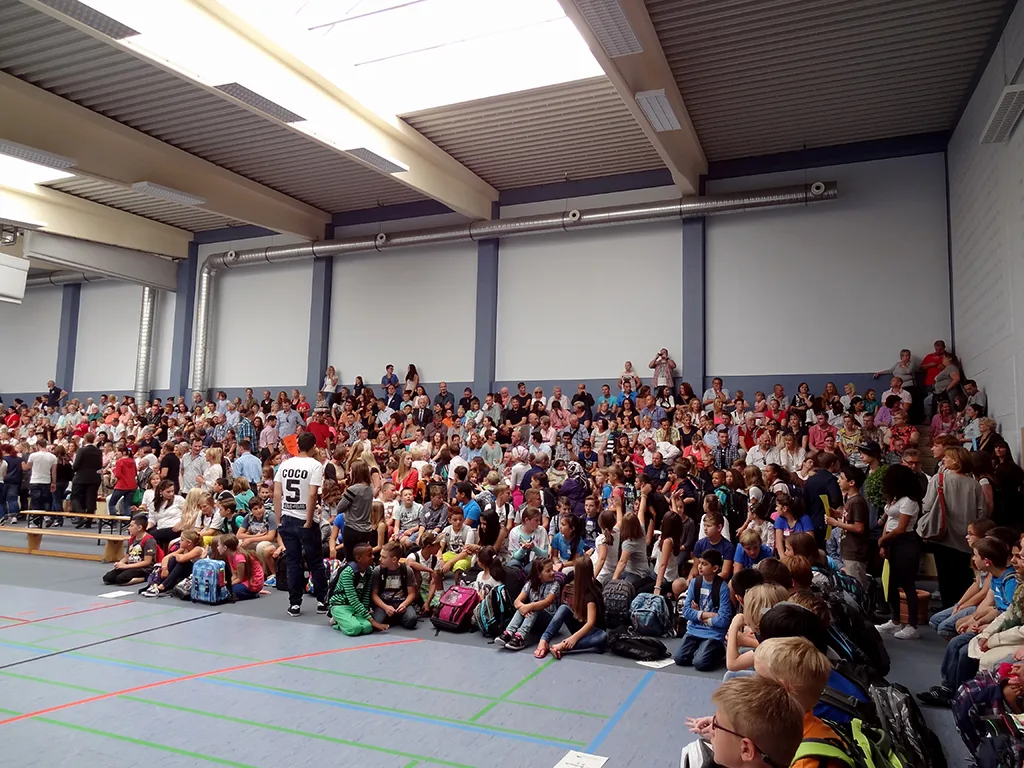 Voll besetzte Sporthalle mit Kindern und Familien.